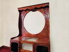 Antique-style carved wooden dressing table with a large framed mirror.