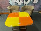 Two wooden chairs with Glass top table